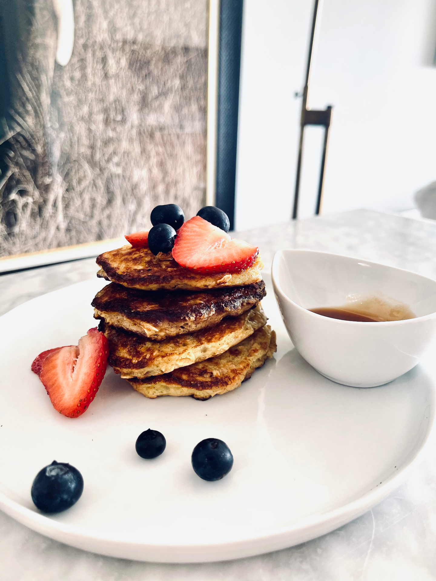 Banana blueberry pancakes served with fresh berries and maple syrup on the side