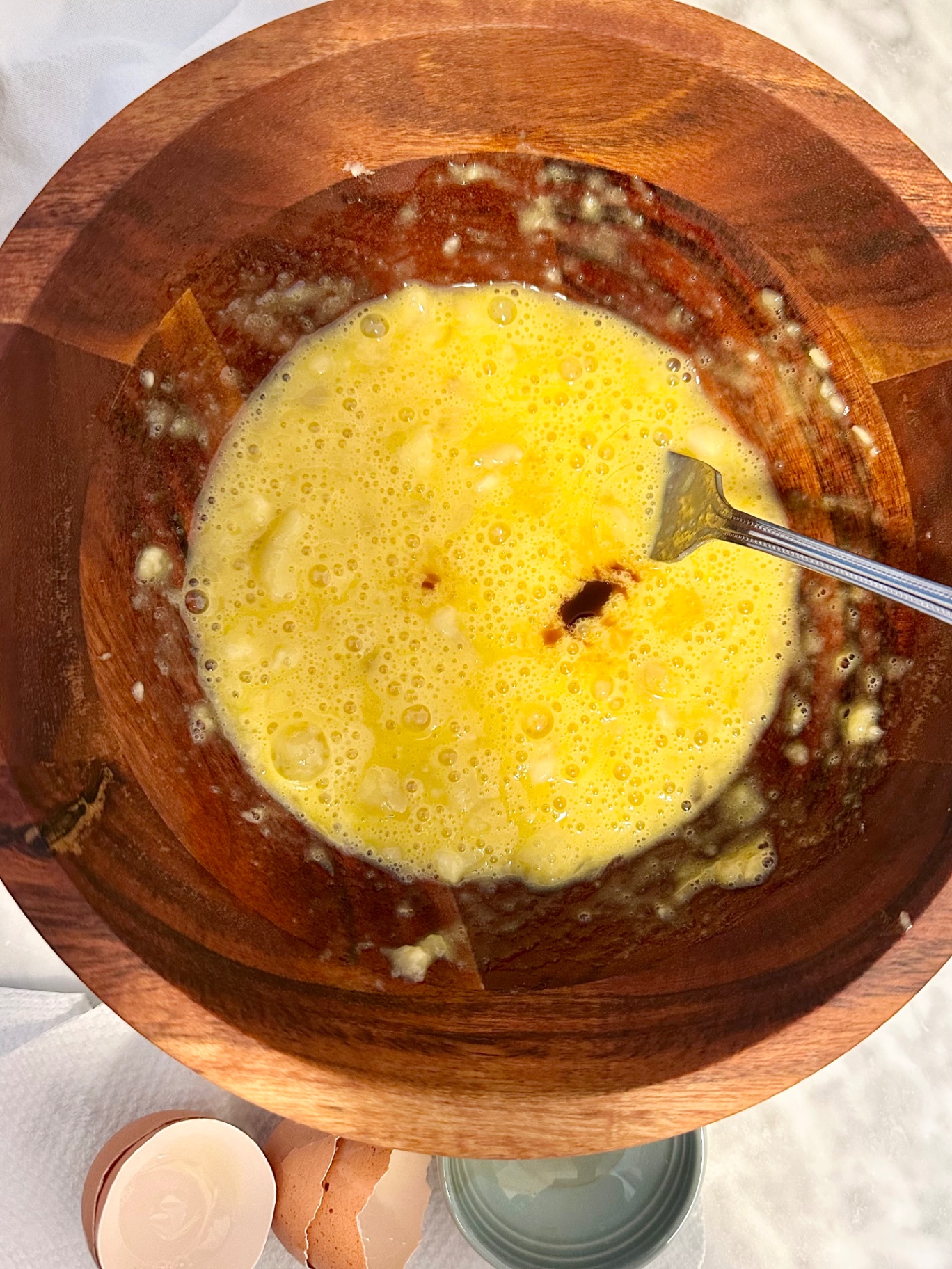 Vanilla added to the banana and egg mixture in a wooden bowl